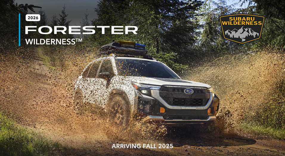 2026 Subaru Forester Wilderness splashing through a wet and muddy trail.